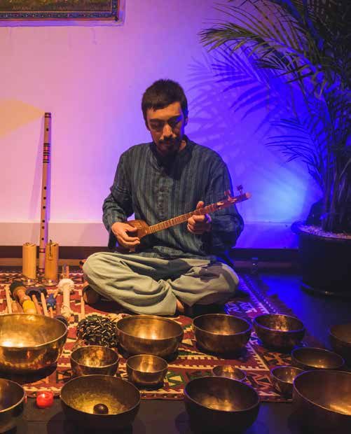 Gustavo A. Pérez J. tocando un setar entre cuencos tibetanos